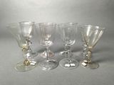 six wine glasses are lined up in a row on a gray surface