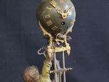 a figurine of a boy holding a clock on a stand