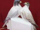 two birds that are sitting on top of a white box