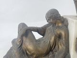 a statue of a woman sitting on top of a marble block