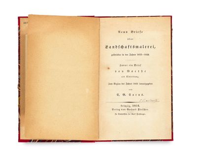 un livre ouvert posé sur une surface blanche, bordé d'un liseré rouge