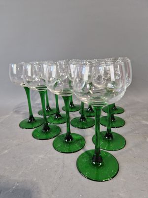 six verres à vin verts empilés les uns sur les autres sur une table