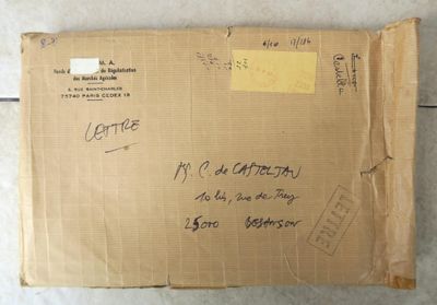 une boîte en carton sur laquelle sont inscrits quelques mots, posée par terre