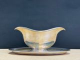 silver gravy on a silver plate on a wooden table