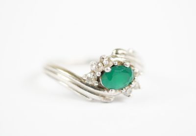 a close up of a ring with a green stone on it