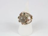 a close up of a ring with a stone in it on a white surface