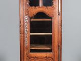 un vieux meuble en bois surmonté d'une porte en verre