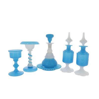 several blue glass candlesticks and vases on a white background