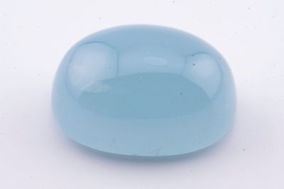 une image représentant une boule de verre bleue posée sur une surface blanche