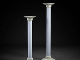 pair of white pedestals against a black background