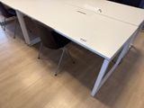 a white table with two chairs and a laptop on it