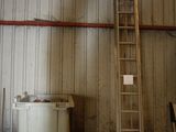 une échelle appuyée contre un mur, à côté d'une poubelle
