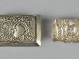 two antique silver buckles, one with a lady and the other with a man ' s face