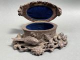 a silver box with a bird on it sitting on a table