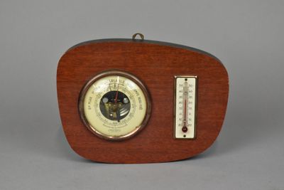 an old fashioned wooden clock with a thermometer on top of it