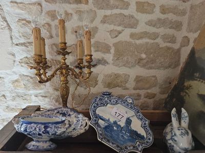 Plusieurs assiettes bleues et blanches ainsi qu'un lustre sont posés sur une table.