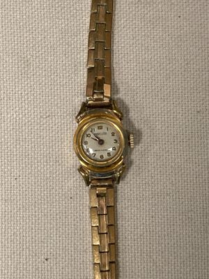 une image d'une montre-bracelet en or avec un cadran blanc