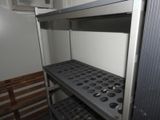 a metal shelf with muffins on it in a room