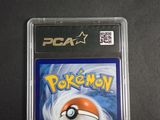 the pokemon card is in a plastic case on a black surface