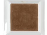 the square white plate has a brown square on it