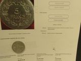 une pièce d'argent posée sur une table, à côté d'une carte
