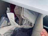 a person ' s hand reaching for a bag of clothes