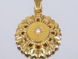 une image représentant un pendentif en or orné d'une perle au centre