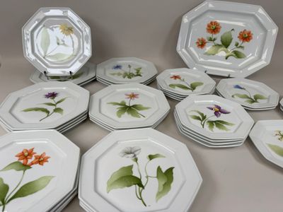 de nombreuses assiettes ornées de fleurs, posées sur une table
