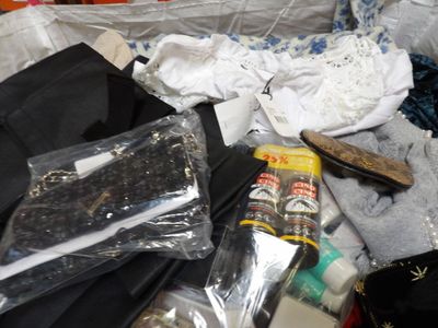 a pile of clothes and other items on a bed