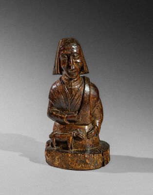 an old wooden statue of a woman sitting on a stool