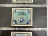 Trois types différents de devises étrangères sont exposés dans une vitrine.