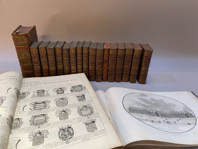 un livre ouvert posé sur une table à côté d'une pile de livres