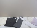 a white table with a bunch of shirts on top of it