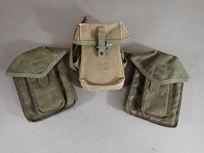 three military pouchs sitting on top of each other on a table