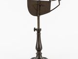 un vieil objet en métal posé sur un socle, avec un fond blanc