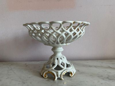 un bol blanc posé sur une table en marbre, avec un mur rose en arrière-plan
