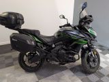 une moto noire et verte garée sur un sol à damier