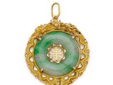 un pendentif en or et en jade vert orné d'un symbole chinois