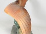 a sculpture of a bird that is sitting on top of a block
