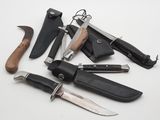 many different types of knives and sheaths laid out on a table
