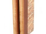 two books are stacked on top of each other on a white surface