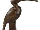 bronze sculpture of a bird with a long beak on a white background