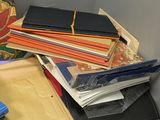 a pile of books sitting on a desk next to a pile of folders