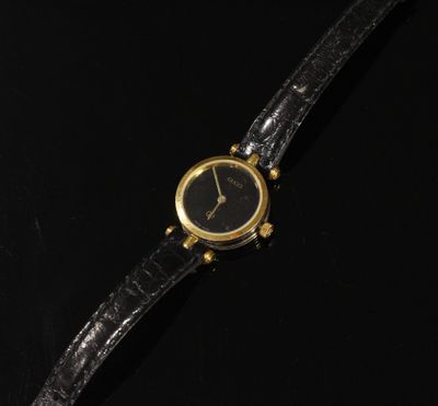 une montre-bracelet plaquée or, avec un cadran noir et un bracelet en cuir noir