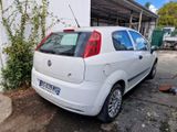 l'arrière d'une petite voiture blanche garée sur un parking