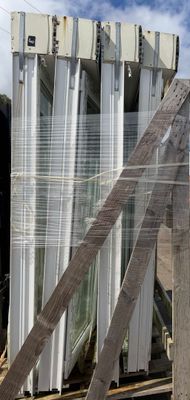 a large pile of windows sitting on a pallet