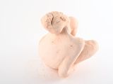 a small figurine of an angel sitting on a white surface