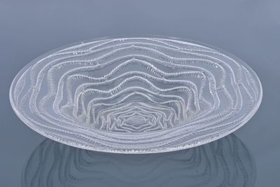 a glass bowl that is sitting on a reflective surface