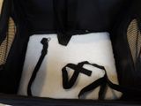 a black bag with a white blanket inside of it