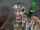 many glasses and a pitcher sitting on a table